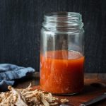 Carolina BBQ Sauce (apple cider vinegar sauce) in a jar with pulled pork.