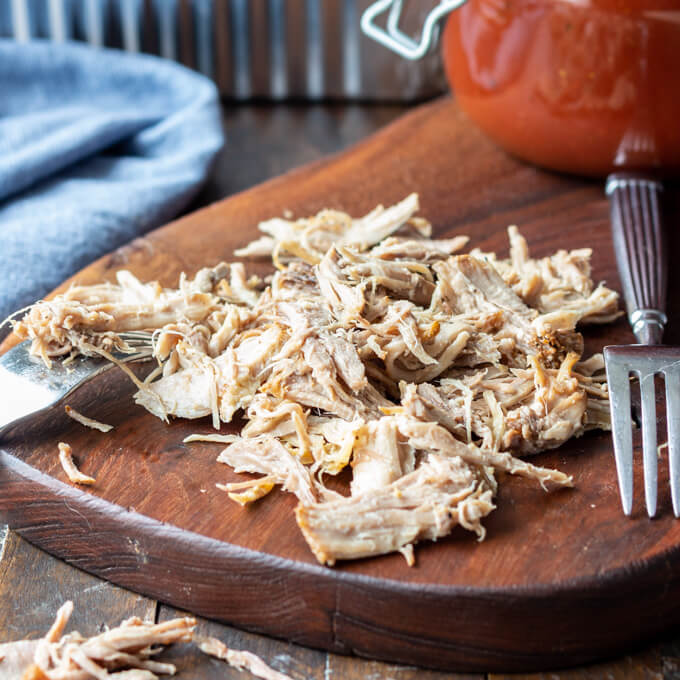 Easy Pulled Pork Recipe is easily shredded with forks on a cutting board.