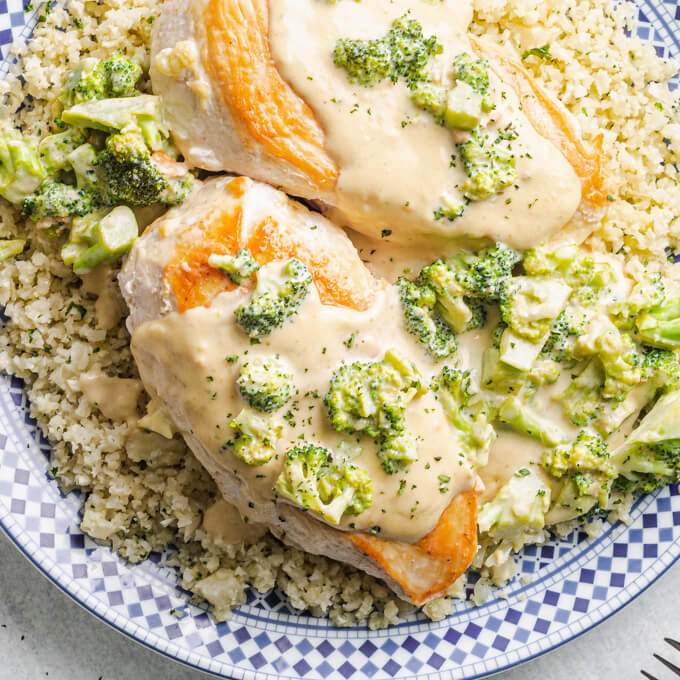 Chicken Broccoli Alfredo over cauliflower rice on a blue and white patterned plate